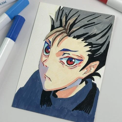 Character portrait on a sketchbook beside markers